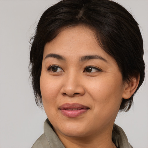 Joyful asian adult female with medium  brown hair and brown eyes