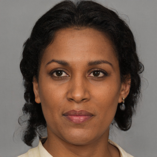 Joyful black adult female with medium  brown hair and brown eyes
