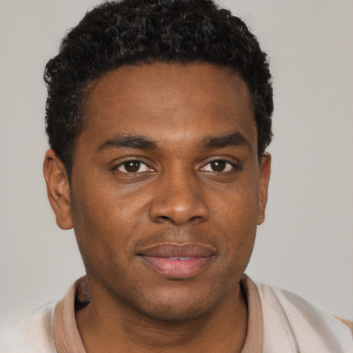 Joyful black young-adult male with short  brown hair and brown eyes