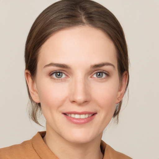 Joyful white young-adult female with medium  brown hair and grey eyes