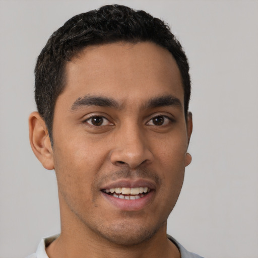 Joyful latino young-adult male with short  brown hair and brown eyes