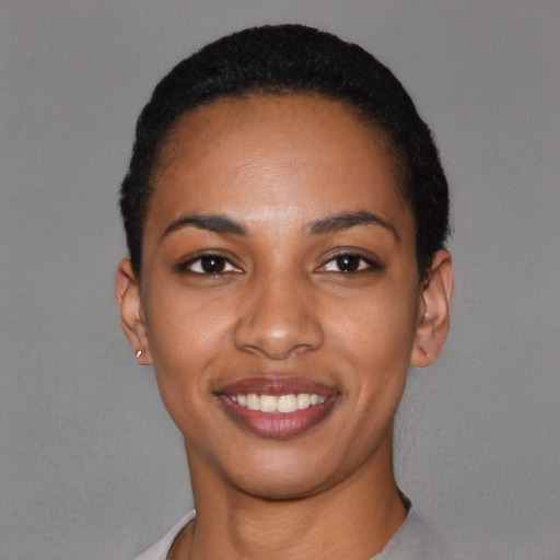 Joyful black young-adult female with short  black hair and brown eyes