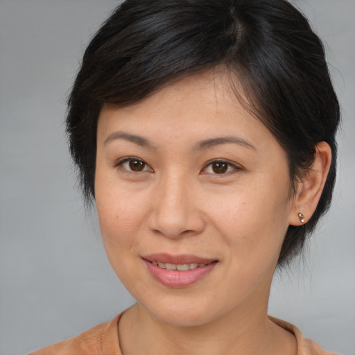 Joyful asian adult female with medium  brown hair and brown eyes