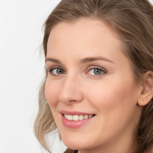 Joyful white young-adult female with long  brown hair and blue eyes