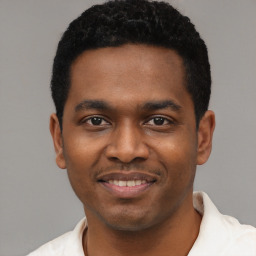 Joyful black young-adult male with short  black hair and brown eyes