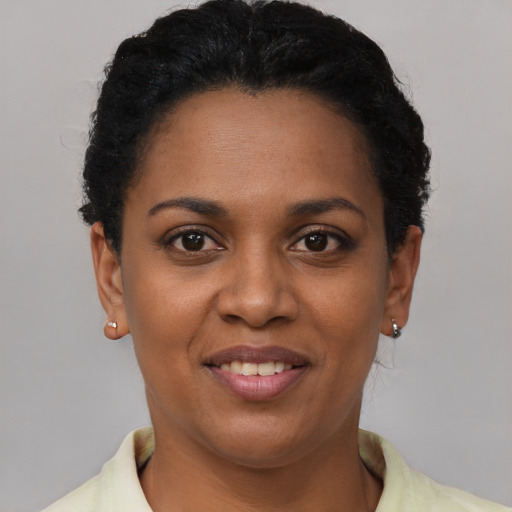 Joyful black young-adult female with short  brown hair and brown eyes