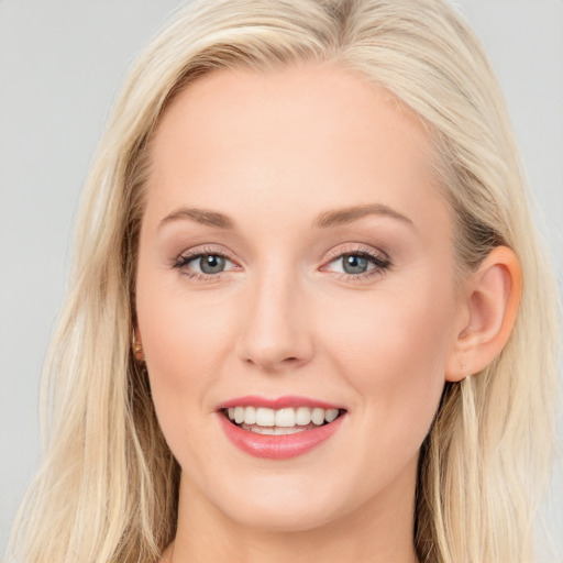 Joyful white young-adult female with long  brown hair and blue eyes