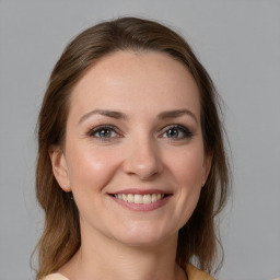 Joyful white young-adult female with medium  brown hair and grey eyes