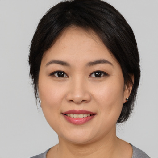 Joyful asian young-adult female with medium  black hair and brown eyes