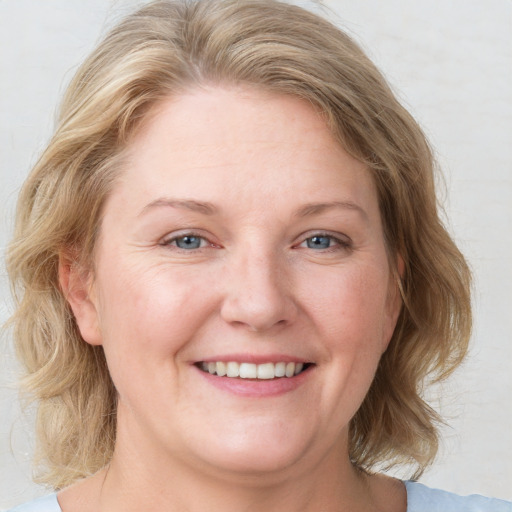 Joyful white adult female with medium  brown hair and blue eyes