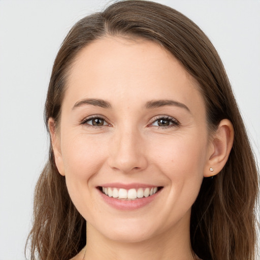 Joyful white young-adult female with long  brown hair and brown eyes