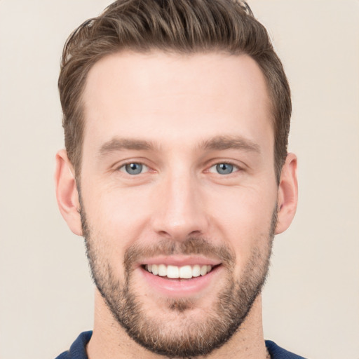 Joyful white young-adult male with short  brown hair and grey eyes