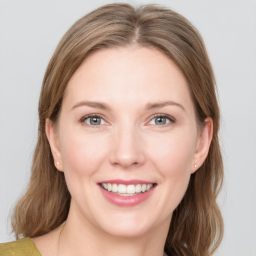 Joyful white young-adult female with medium  brown hair and blue eyes