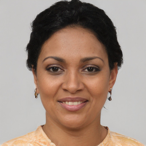 Joyful latino young-adult female with short  black hair and brown eyes