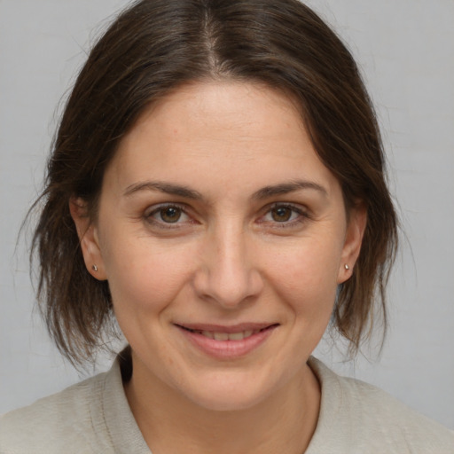 Joyful white adult female with medium  brown hair and brown eyes