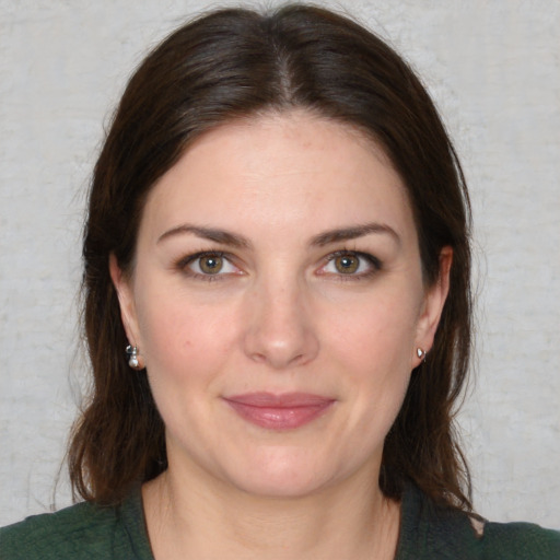 Joyful white young-adult female with medium  brown hair and green eyes