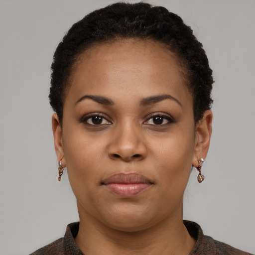 Joyful black young-adult female with short  black hair and brown eyes
