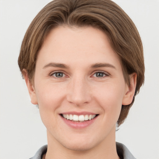 Joyful white young-adult female with short  brown hair and grey eyes