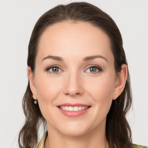 Joyful white young-adult female with long  brown hair and grey eyes