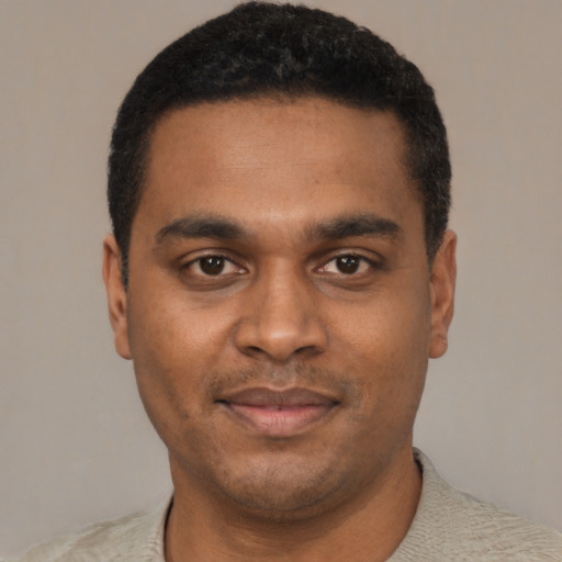 Joyful black young-adult male with short  black hair and brown eyes