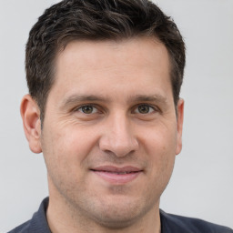 Joyful white adult male with short  brown hair and grey eyes