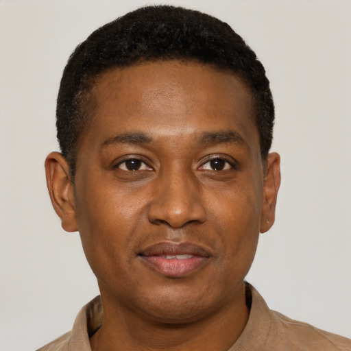Joyful black young-adult male with short  brown hair and brown eyes