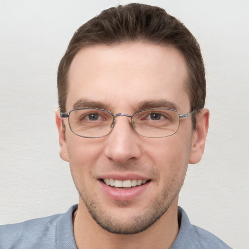 Joyful white young-adult male with short  brown hair and grey eyes