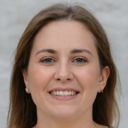 Joyful white adult female with long  brown hair and grey eyes