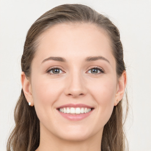 Joyful white young-adult female with long  brown hair and grey eyes