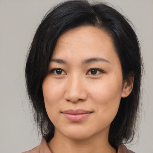 Joyful asian young-adult female with medium  brown hair and brown eyes