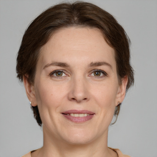 Joyful white adult female with medium  brown hair and grey eyes