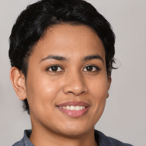 Joyful latino young-adult female with short  black hair and brown eyes