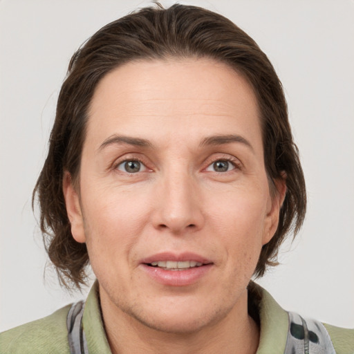 Joyful white adult female with medium  brown hair and grey eyes