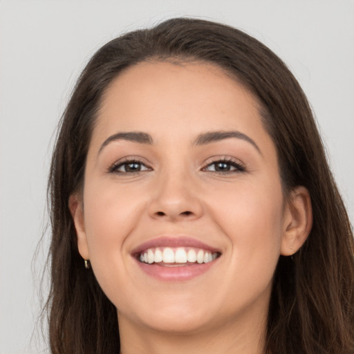 Joyful white young-adult female with long  brown hair and brown eyes