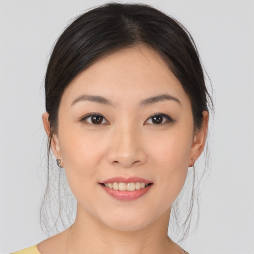Joyful asian young-adult female with medium  brown hair and brown eyes