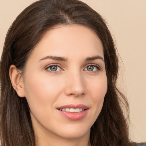 Joyful white young-adult female with long  brown hair and brown eyes