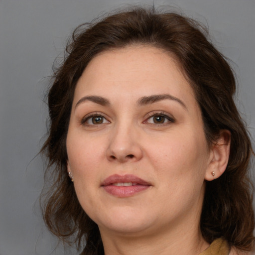 Joyful white adult female with long  brown hair and brown eyes