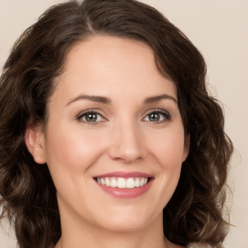 Joyful white young-adult female with medium  brown hair and green eyes