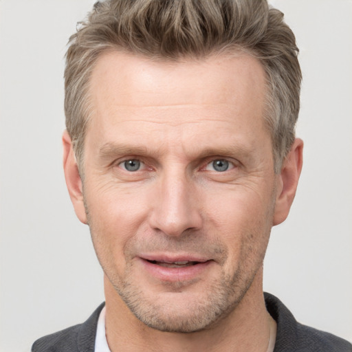 Joyful white adult male with short  brown hair and grey eyes