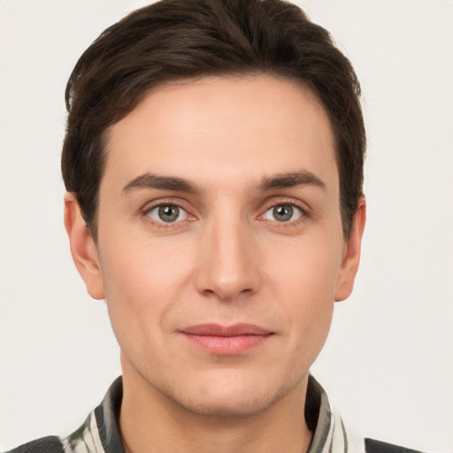 Joyful white young-adult male with short  brown hair and grey eyes