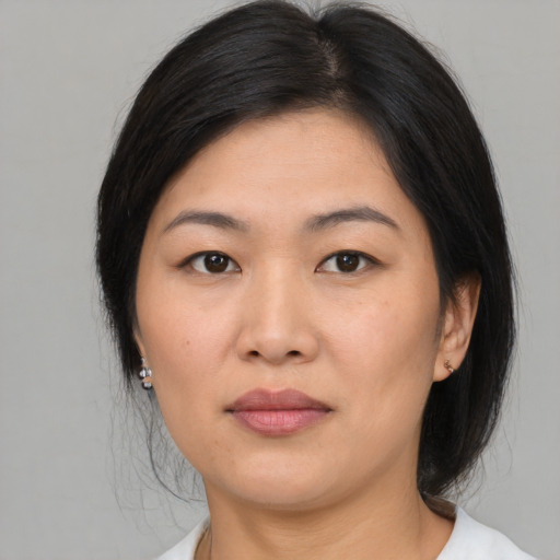 Joyful asian young-adult female with medium  brown hair and brown eyes
