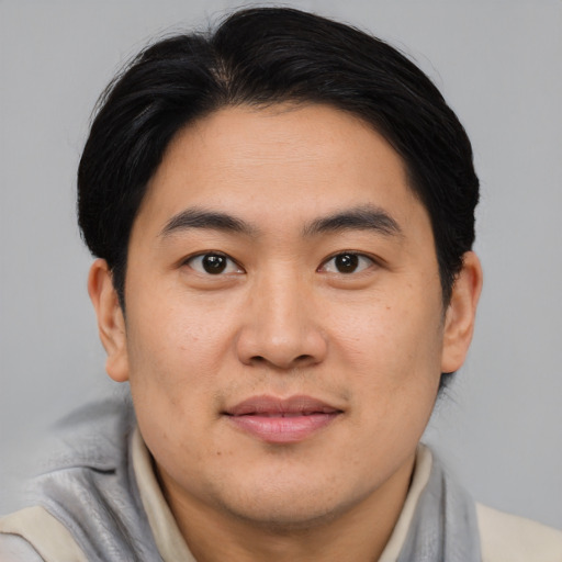 Joyful asian young-adult male with short  brown hair and brown eyes