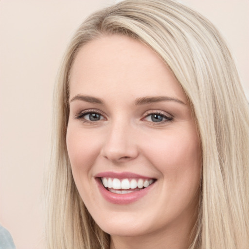 Joyful white young-adult female with long  brown hair and blue eyes