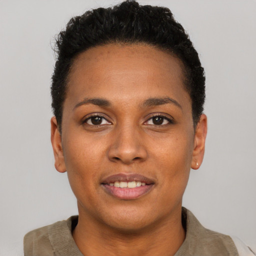 Joyful black young-adult female with short  black hair and brown eyes