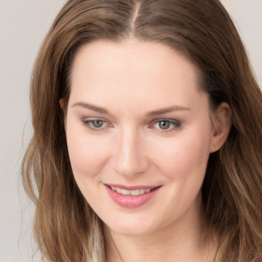 Joyful white young-adult female with long  brown hair and grey eyes