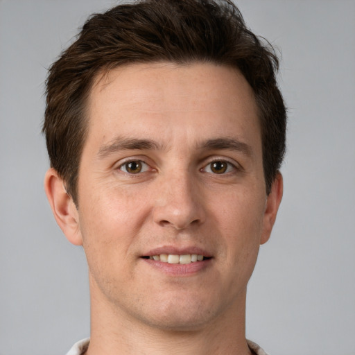 Joyful white young-adult male with short  brown hair and grey eyes