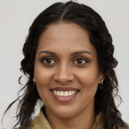 Joyful black young-adult female with long  brown hair and brown eyes