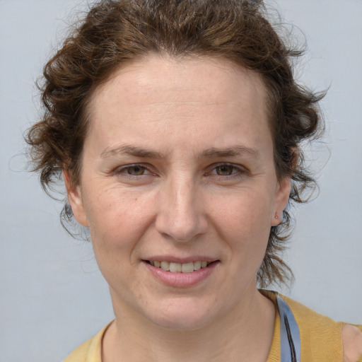 Joyful white adult female with medium  brown hair and blue eyes