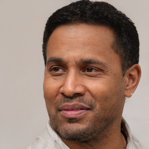 Joyful latino adult male with short  black hair and brown eyes