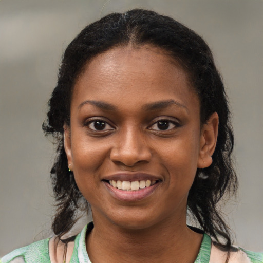Joyful black young-adult female with medium  brown hair and brown eyes